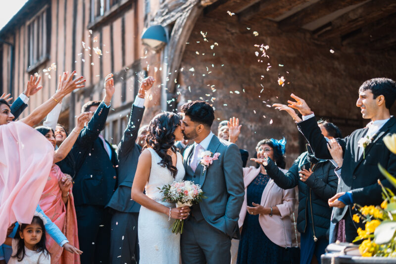 A wedding party throwing confetti at each other.