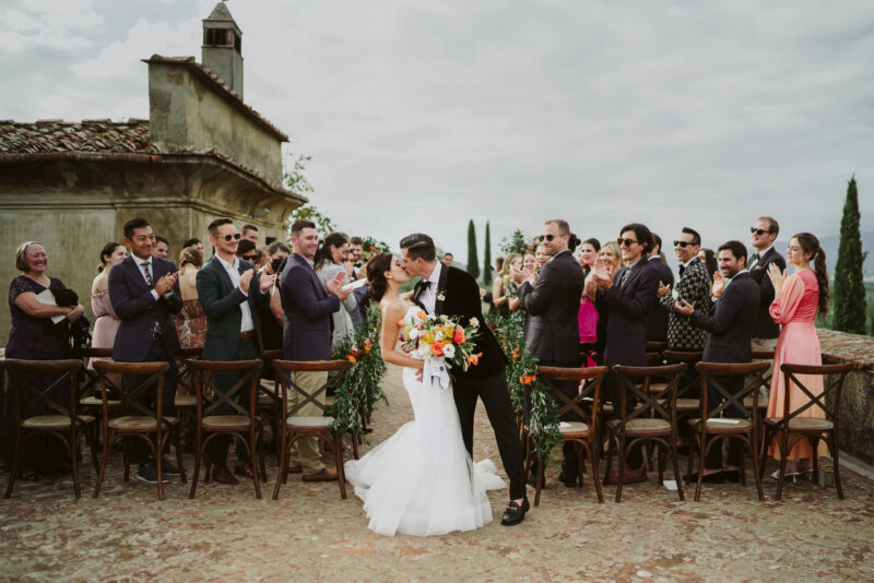 A bride and groom kissing at their wedding ceremony in tuscany.